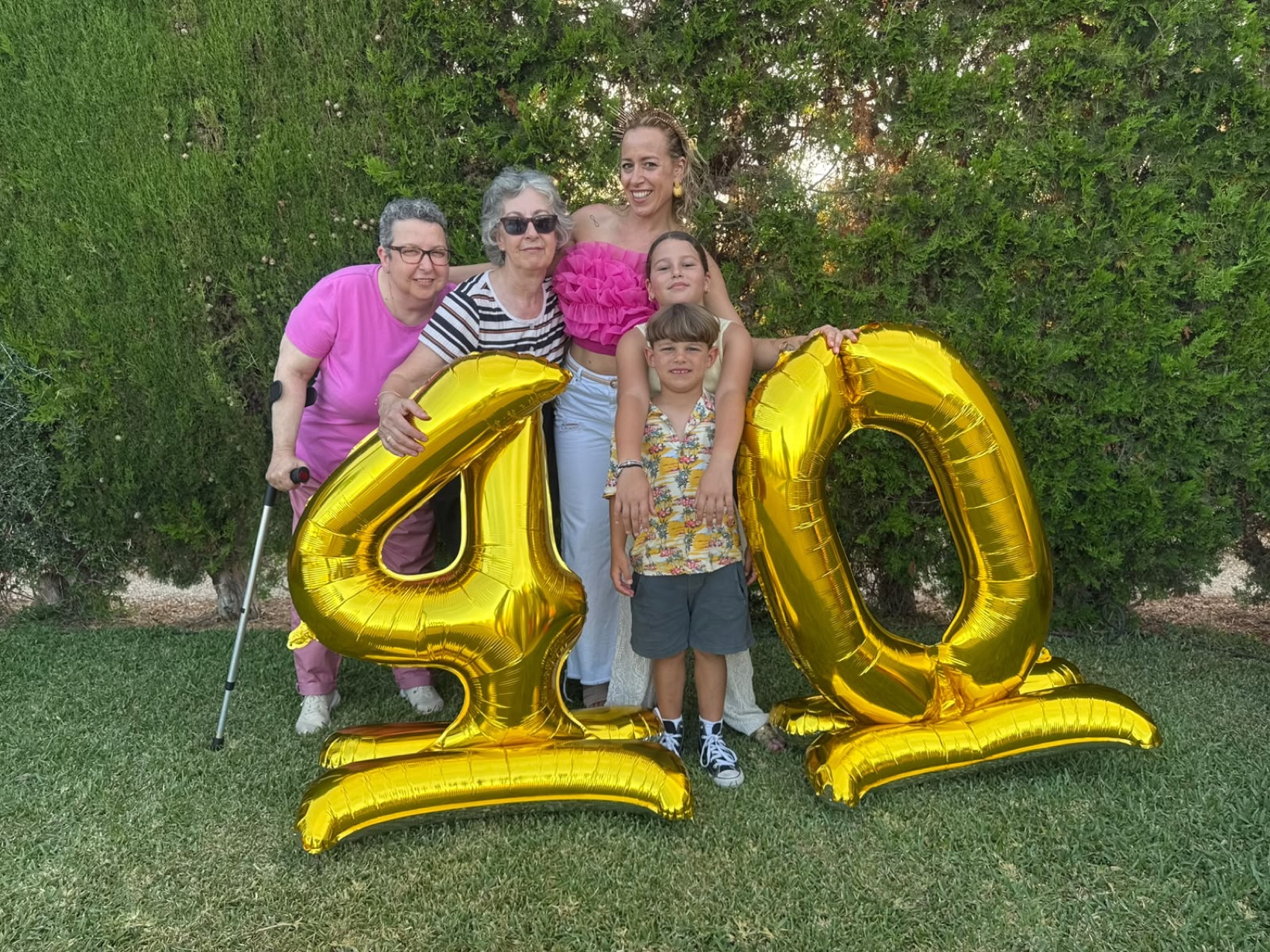 Elena celebrando junto a globos dorados de 40.